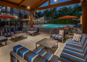 Thumbnail 25 of 47 - a large patio with chairs and umbrellas near a swimming pool