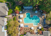 Thumbnail 3 of 40 - An aerial view of a swimming pool surrounded by trees and houses.