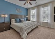 Thumbnail 23 of 40 - A bedroom with a bed, dresser, and ceiling fan.