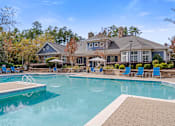 Thumbnail 9 of 40 - A large house with a pool in front.