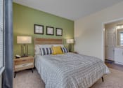 Thumbnail 26 of 40 - A bedroom with a bed, nightstands, and pictures on the wall.