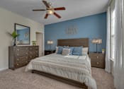 Thumbnail 18 of 40 - A bedroom with a large bed, a dresser, and a ceiling fan.