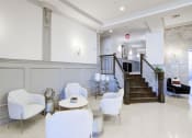 Thumbnail 16 of 28 - a lobby with white chairs and a staircase in the background