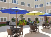 Thumbnail 25 of 28 - a patio with tables and umbrellas in front of a building