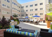 Thumbnail 22 of 28 - a patio with a grill and tables with umbrellas