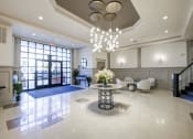 Thumbnail 12 of 28 - a large lobby with a table with a vase of flowers on it