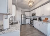 Thumbnail 2 of 41 - A kitchen with white cabinets and a marble countertop. at Barton Creek Villas, Austin, TX