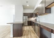 Thumbnail 14 of 30 - a kitchen with dark wood cabinets and stainless steel appliances at RockVue, Broomfield, 80021