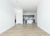 Thumbnail 9 of 30 - a spacious living room with a kitchen in the background at RockVue, Broomfield, CO