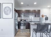 Thumbnail 10 of 30 - a kitchen with wooden cabinets and stainless steel appliances at RockVue, Broomfield, CO