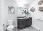Thumbnail 19 of 30 - a bathroom with a toilet sink and mirror at Rockvue, Broomfield