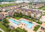 Thumbnail 1 of 28 - an aerial view of an apartment complex with a large swimming pool at Retreat at Shadow Creek Ranch Apartments, Woodburn, TX, 77584