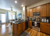 Thumbnail 22 of 28 - a kitchen with a stove top oven next to a sink at Retreat at Shadow Creek Ranch Apartments, Woodburn, TX, 77584