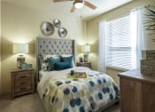 Thumbnail 20 of 28 - a bedroom with a bed and a ceiling fan at Retreat at Shadow Creek Ranch Apartments, Texas