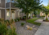 Thumbnail 44 of 47 - a front yard with a tree and a rock in front of a house