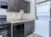 Thumbnail 5 of 12 - a kitchen with black cabinets and white appliances at Parkland Village, Forestville