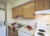 Thumbnail 7 of 12 - a kitchen with wooden cabinets and white appliances at Parkland Village, Forestville
