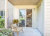 Thumbnail 10 of 24 - the front porch of a house with a chair and a door at Eagles Landing Apartments, Everett, 98204