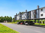 Thumbnail 24 of 24 - a parking lot with cars in front of an apartment building at Eagles Landing Apartments, Everett, WA 98204