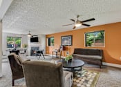 Thumbnail 14 of 24 - a living room with couches and a table and a ceiling fan at Eagles Landing Apartments, Everett, WA