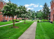 Thumbnail 10 of 12 - a sidewalk leading to a gazebo in front of a brick building at Parkland Village, Forestville Maryland