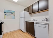 Thumbnail 5 of 24 - a small kitchen with a white dishwasher and a refrigerator at Eagles Landing Apartments, Everett