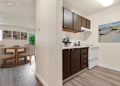 Thumbnail 3 of 24 - a kitchen and dining room area with a table and chairs and a wall at Eagles Landing Apartments, Washington