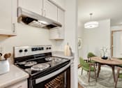 Thumbnail 16 of 22 - a kitchen with a stove and a dining room with a table and chairs at Sage Apartments, Washington, 98204
