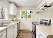 Thumbnail 15 of 22 - a modern kitchen with white cabinets and stainless steel appliances at Sage Apartments, Washington