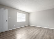 Thumbnail 7 of 16 - an empty room with wooden floors and a white door