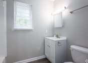 Thumbnail 12 of 16 - an empty bathroom with a toilet and a sink and a window