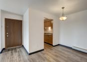 Thumbnail 18 of 47 - a bedroom with hardwood flooring and a door leading to a kitchen