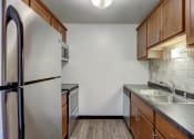 Thumbnail 15 of 47 - a kitchen with wooden cabinets and stainless steel appliances