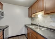 Thumbnail 16 of 47 - a kitchen with wooden cabinets and stainless steel appliances