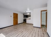 Thumbnail 33 of 47 - a living room with a hardwood floor and a kitchen in the background