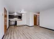 Thumbnail 32 of 47 - an empty living room with a kitchen in the background