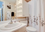 Thumbnail 42 of 43 - A white bathroom with a floral shower curtain.