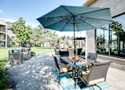 Thumbnail 23 of 43 - A patio with a table and chairs under an umbrella.