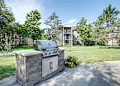 Thumbnail 28 of 43 - A stone grill is in the foreground of a residential area.