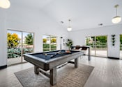 Thumbnail 16 of 60 - a pool table in a living room with a view of a dining room