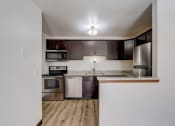 Thumbnail 28 of 47 - a kitchen with dark wood cabinets and stainless steel appliances