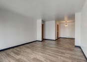 Thumbnail 19 of 47 - an empty living room with hardwood floors and white walls