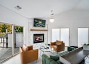 Thumbnail 15 of 60 - a living room with a fireplace and a table and chairs