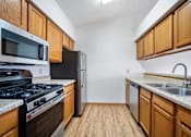 Thumbnail 29 of 60 - a kitchen with wooden cabinets and stainless steel appliances