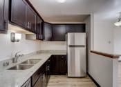 Thumbnail 29 of 47 - a kitchen with dark cabinets and a white refrigerator