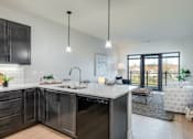 Thumbnail 3 of 18 - A modern kitchen with dark wood cabinets and a white countertop.