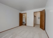 Thumbnail 27 of 47 - a bedroom with white walls and a carpeted floor