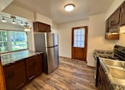 Thumbnail 12 of 16 - A kitchen with a refrigerator, stove, and sink.