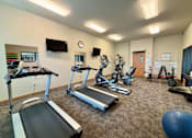 Thumbnail 9 of 34 - A gym with treadmills, exercise bikes, and other equipment.
