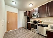Thumbnail 31 of 34 - A kitchen with brown cabinets and stainless steel appliances.